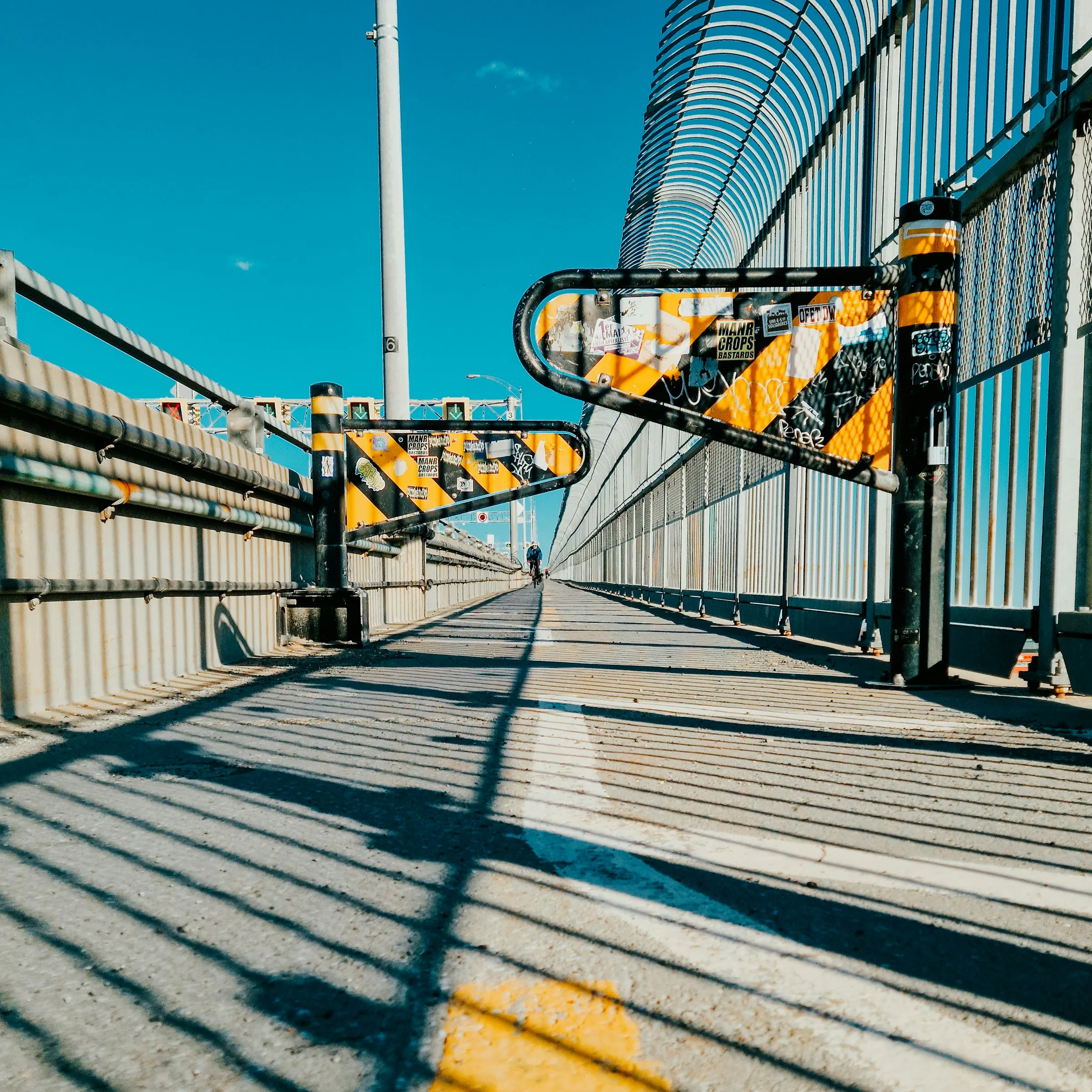 Passerelle piétonne aux rambardes jaunes et noires à Saint-Léonard