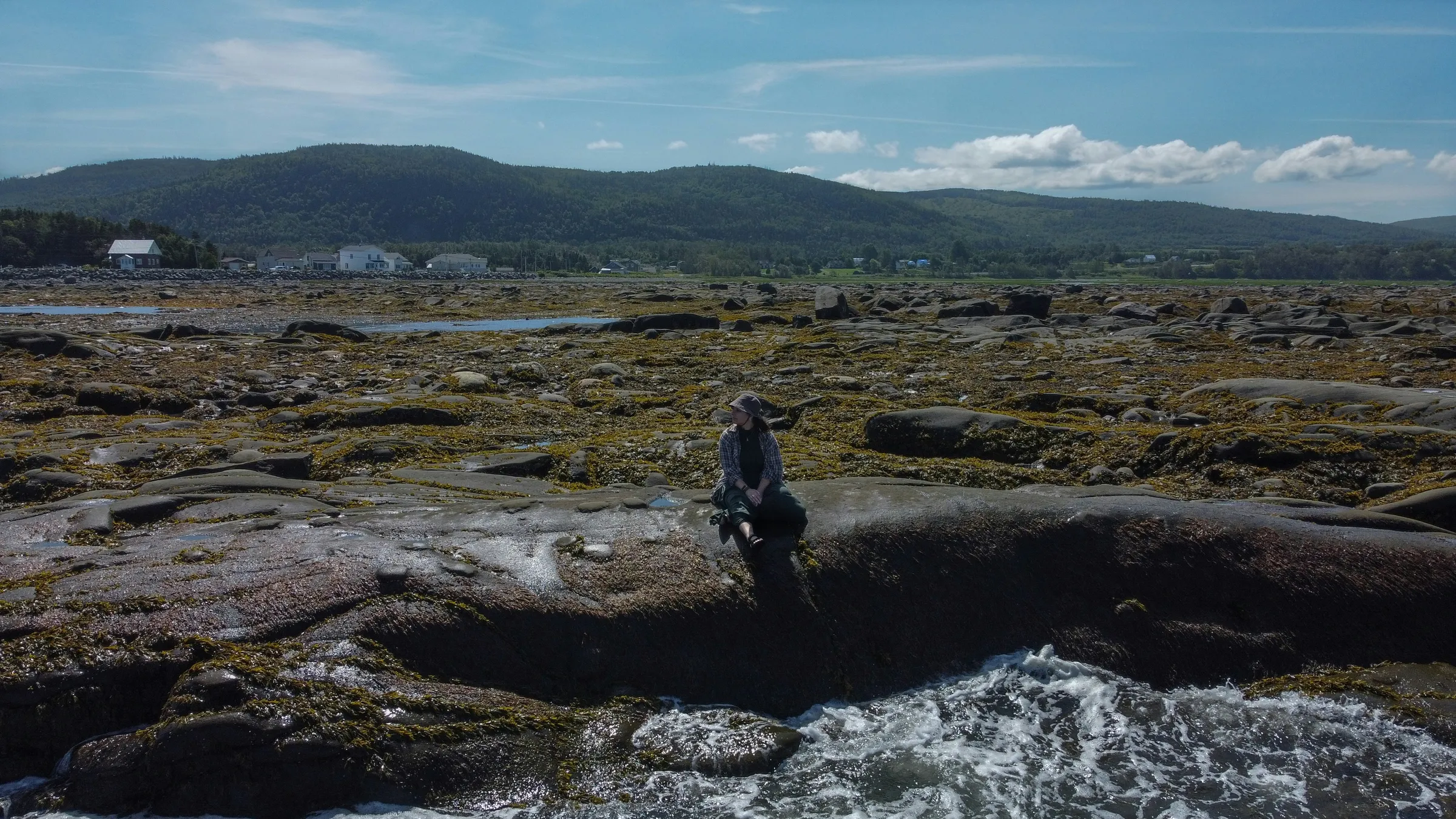 a man standing on top of a rock covered beach