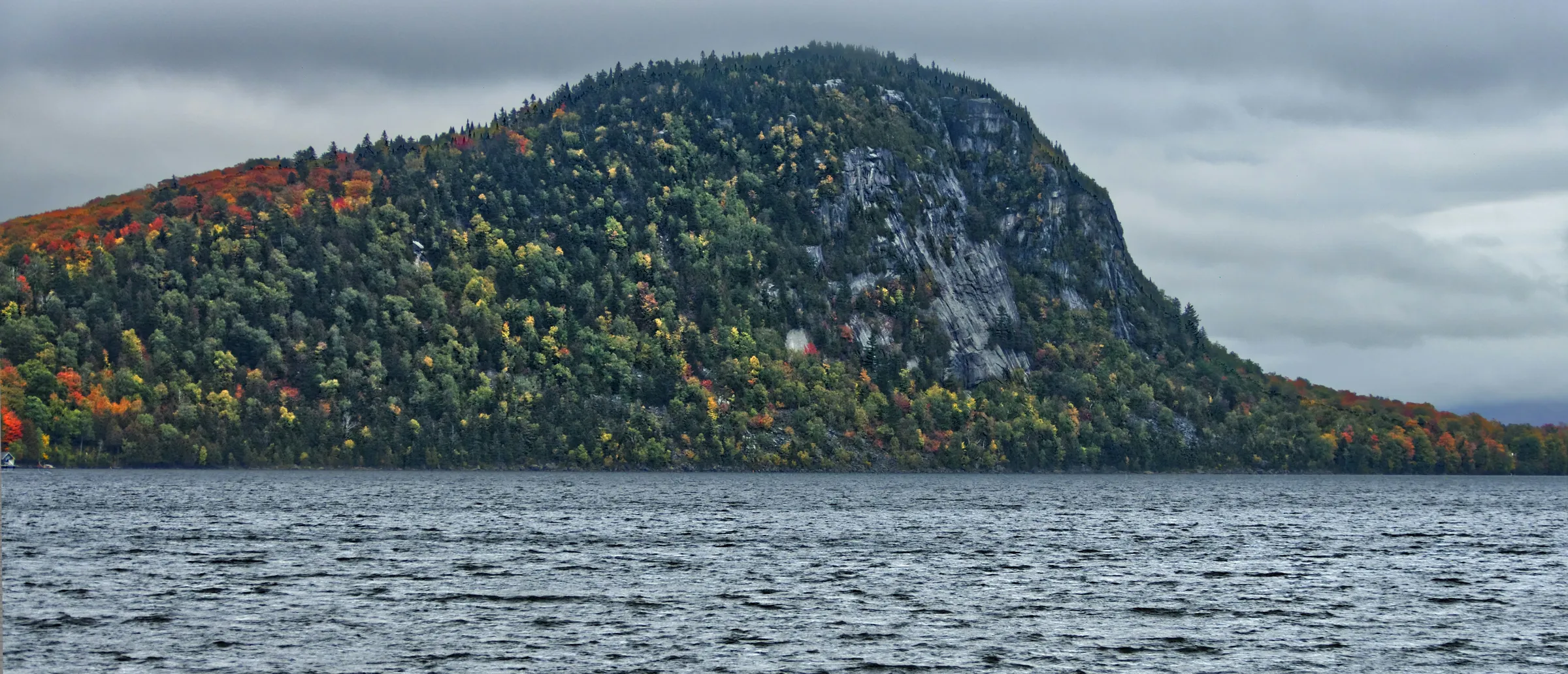 green and brown mountains near body of water during daytime