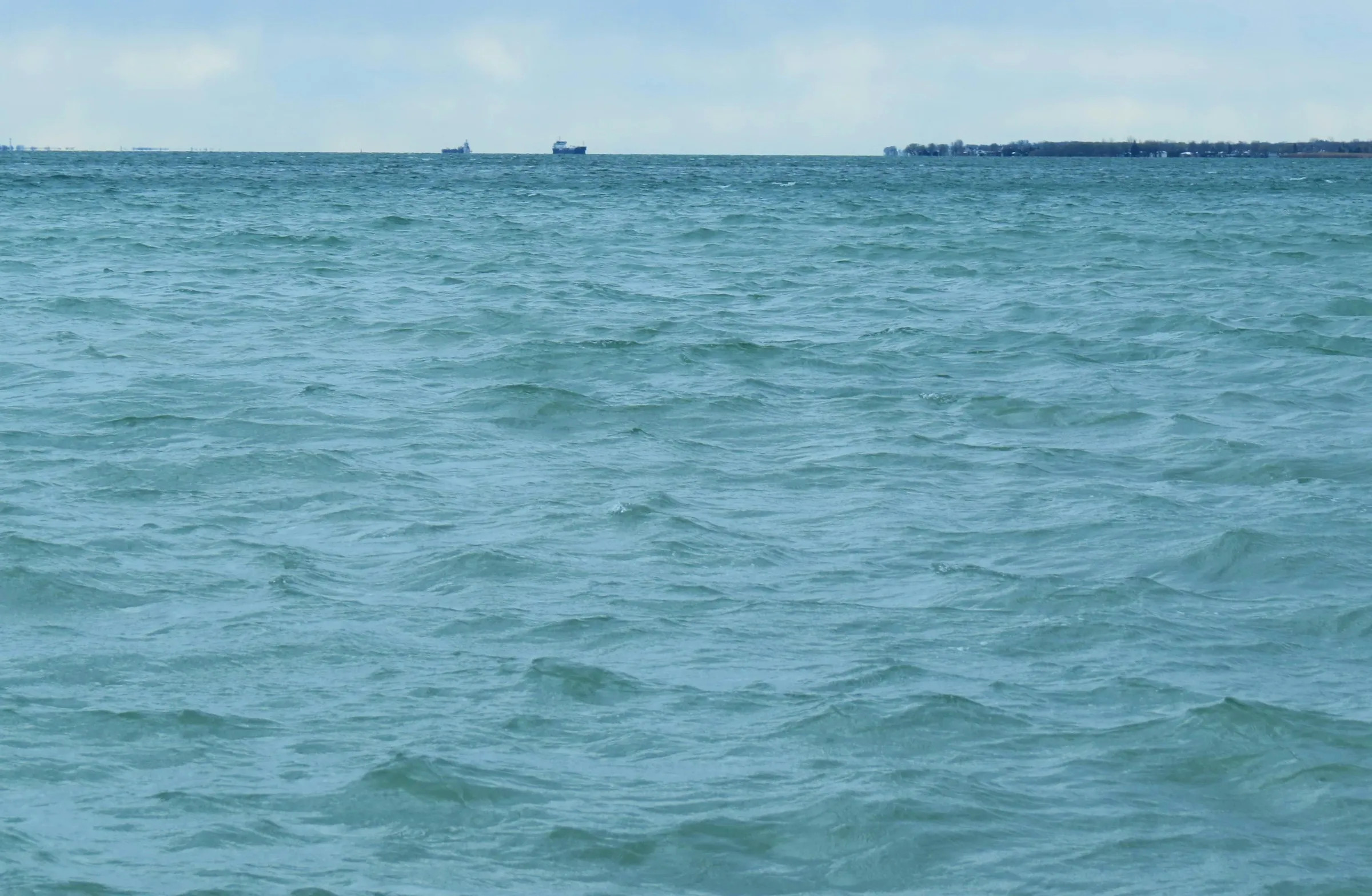 a large body of water with a boat in the distance