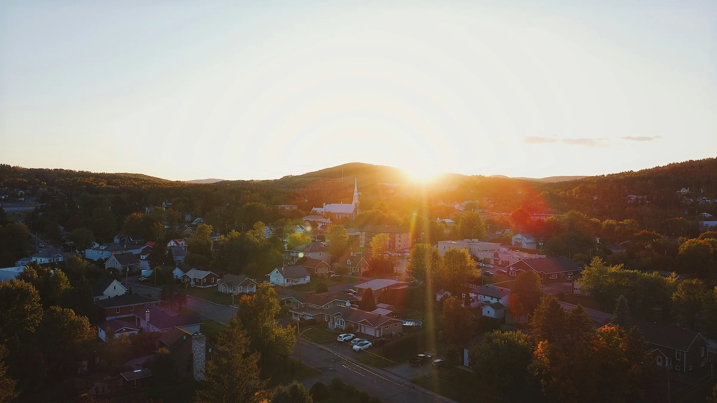 Sunset over a small town nestled in hills