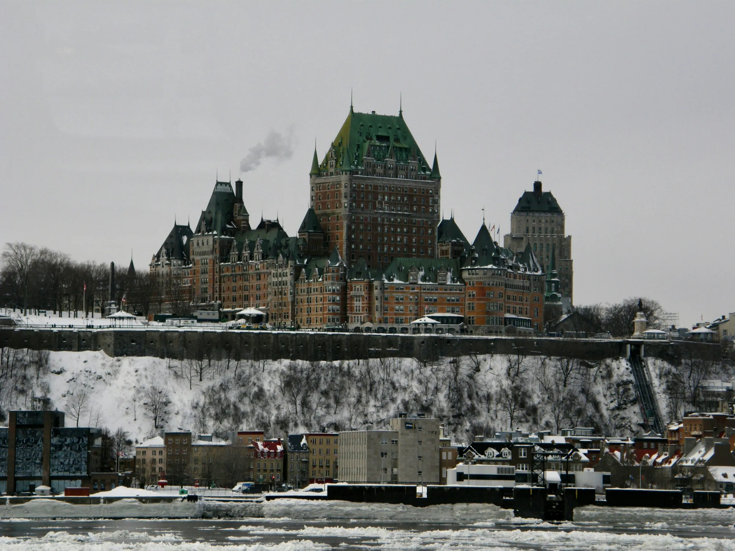 a large building with a green roof on a snowy day