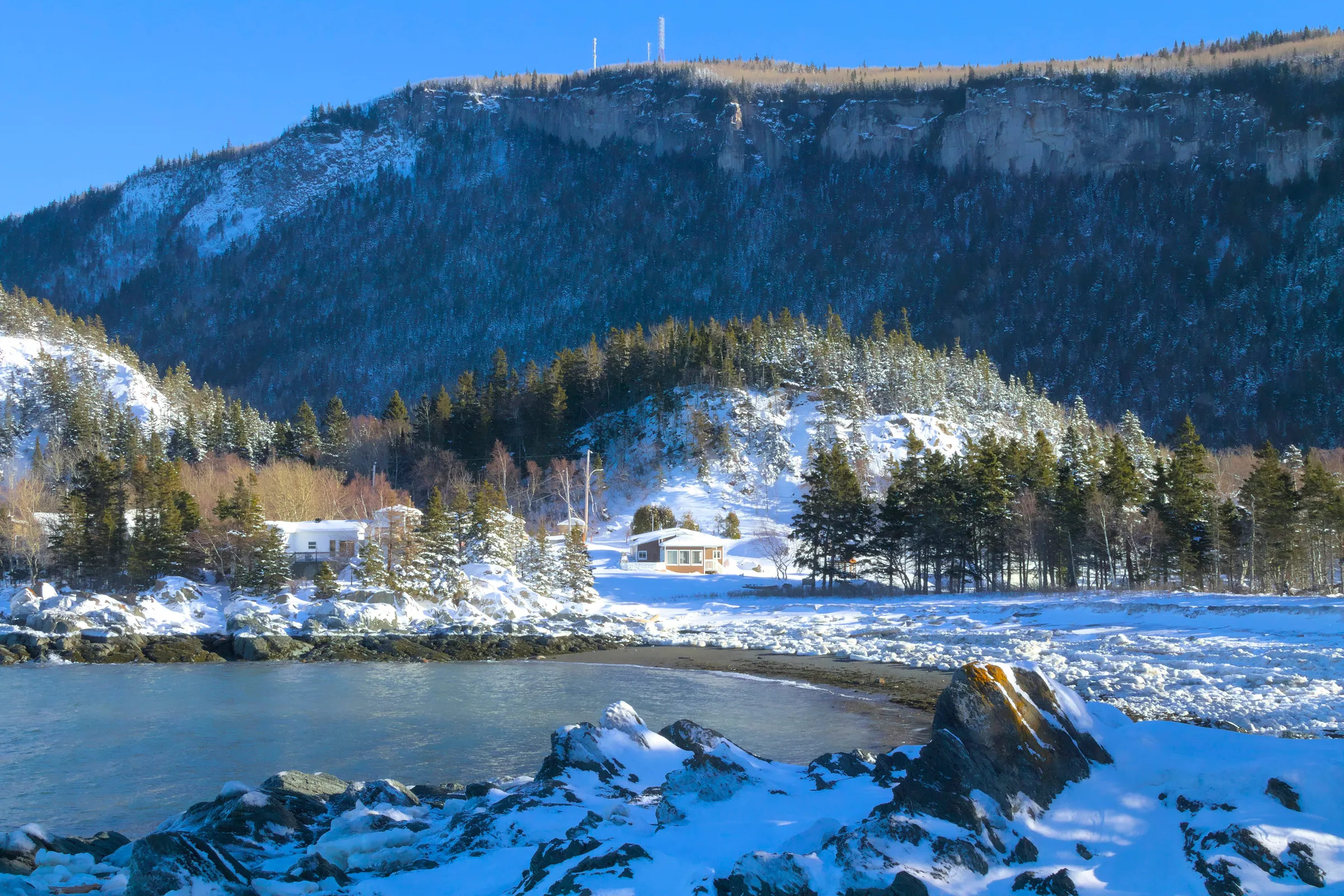 A lake surrounded by mountains covered in snow
