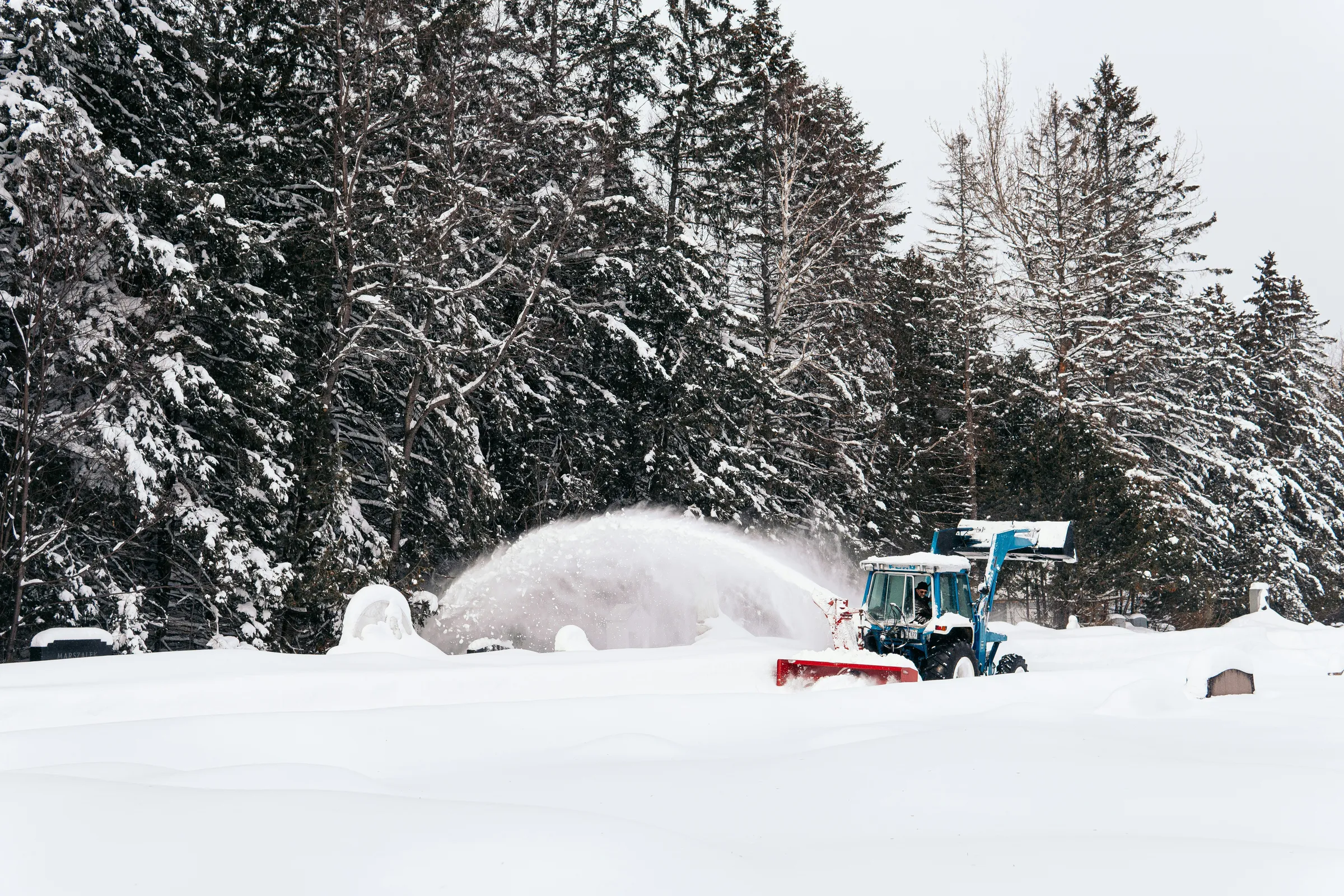man riding on red and black snow mobile during daytime