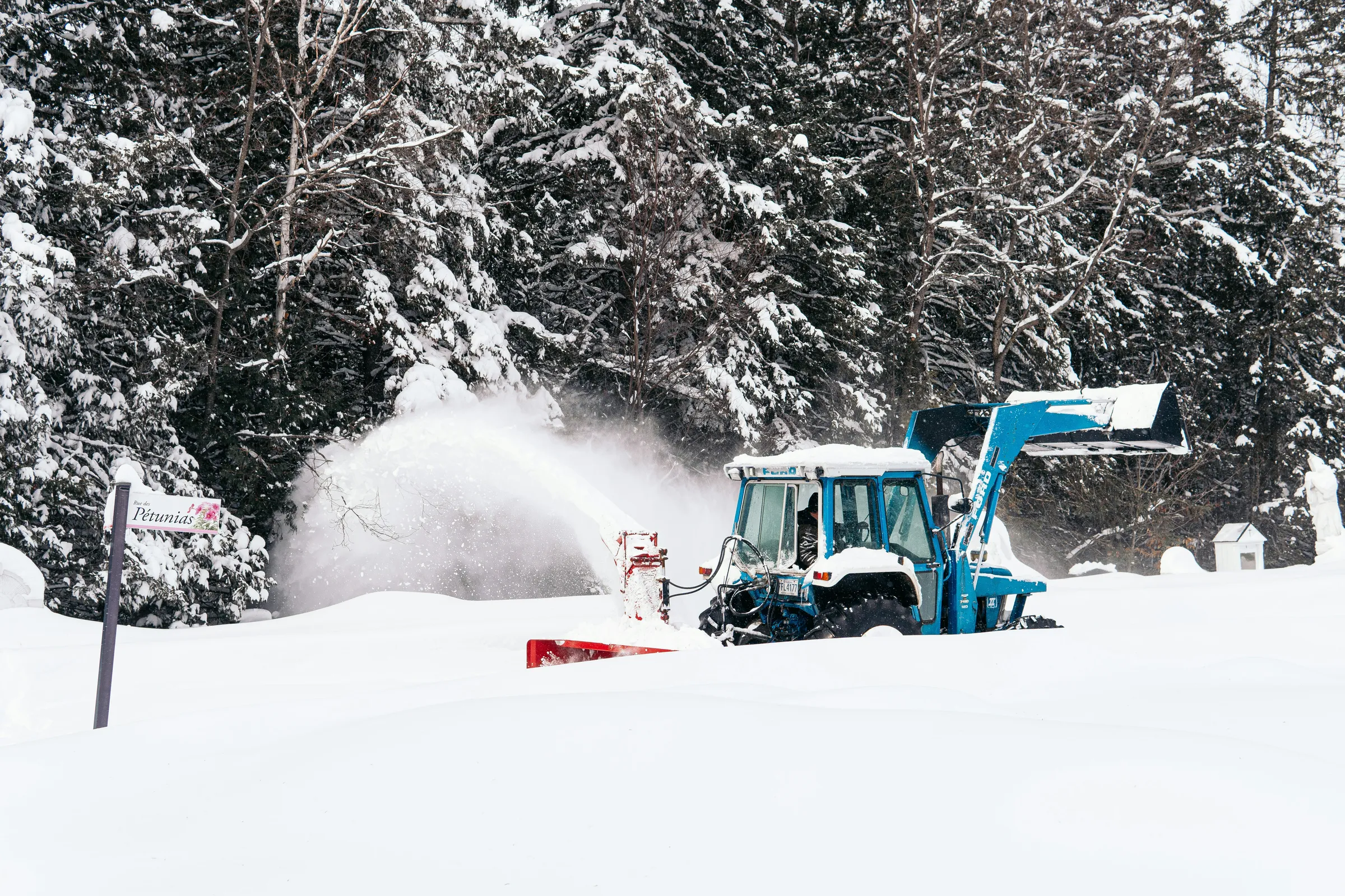 red and black tractor on snow covered ground during daytime