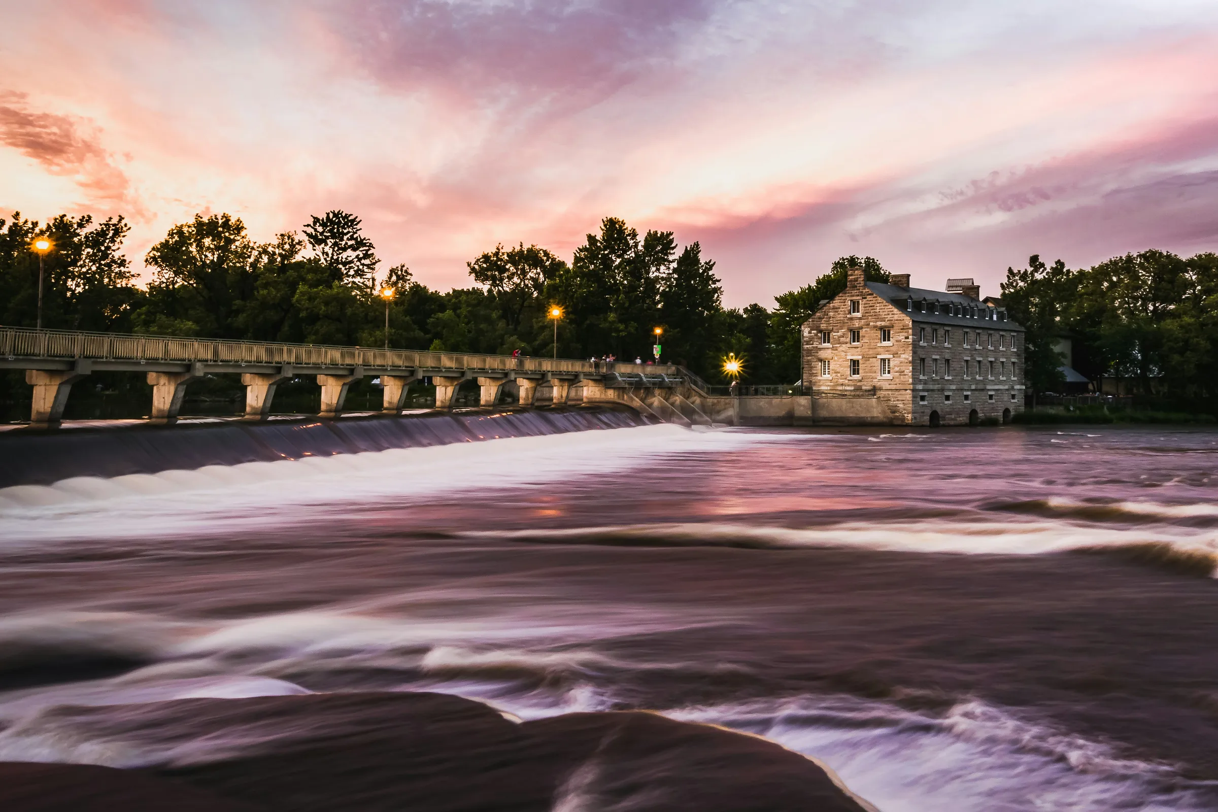 time lapse photography of river near trees and building