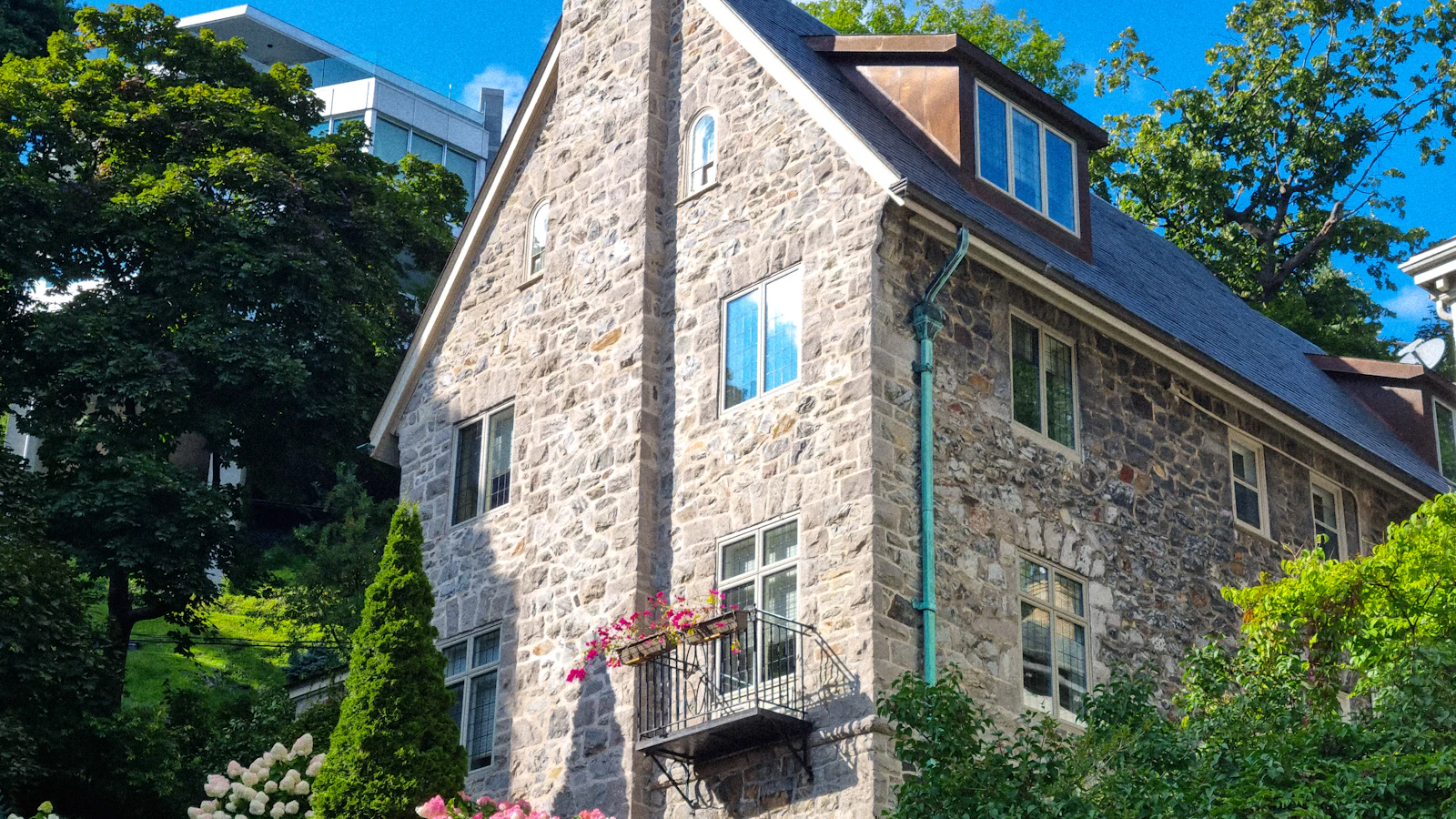 a large stone house with a steeple and flowers on the front